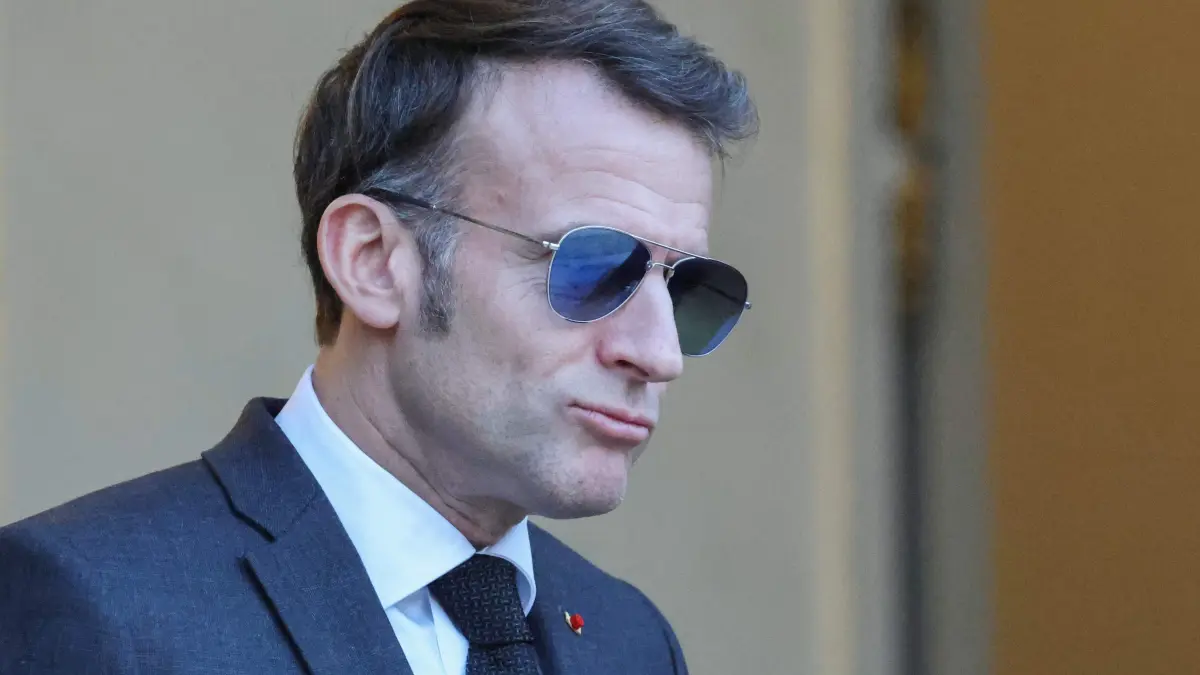 France's President Emmanuel Macron wearing sunglasses reacts as he waits for Lebanon's Prime Minister's arrival prior to their meeting at the Elysee presidential palace in Paris, on January 23, 2026. (Photo by Ludovic MARIN / AFP)