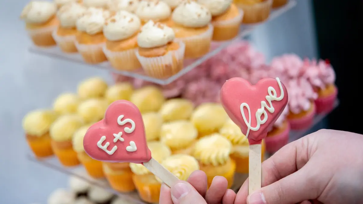 Hochzeitsmesse Oldenburg: 24.01.2026, Niedersachsen, Oldenburg: Eine Konditorin präsentiert an einem Stand auf der Hochzeitsmesse zwei personalisierte Cake-Pops. Auf der Hochzeitsmesse in den Oldenburger Weser-Ems-Hallen präsentieren rund 60 Aussteller am Wochenende aktuelle Trends der Branche. Foto: Hauke-Christian Dittrich/dpa +++ dpa-Bildfunk +++