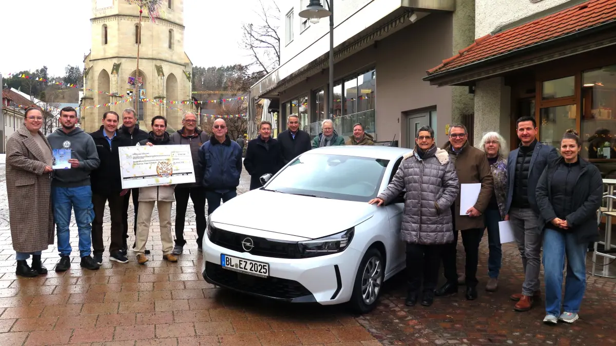 Sandra Pfeffer und Sven Faigle (links) freuen sich über den Opel Corsa, Karl-Heinz Schumann und Hans Edelmann (Sechster und Siebter von links) über den Spendenscheck.