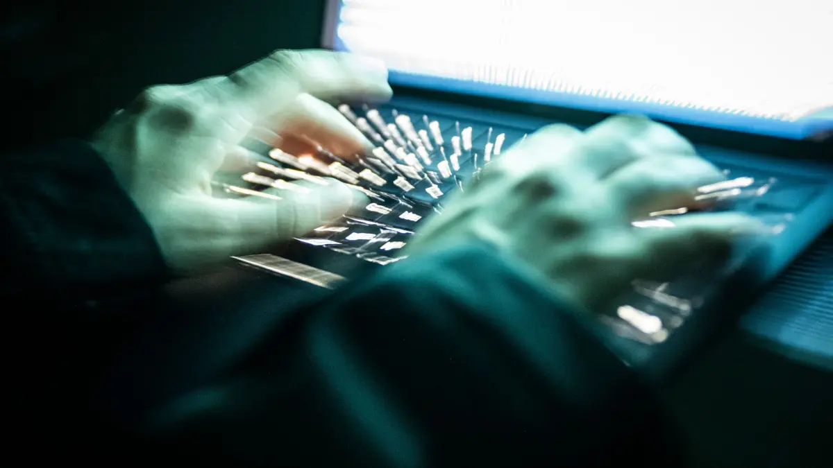 Cyberkriminalität: ILLUSTRATION - 14.12.2025, NA, Berlin: Eine Person tippt mit den Fingern auf einer beleuchteten Laptop-Tastatur.(gestellte Szene, Aufnahme mit Langzeitbelichtung) (zu dpa: «Konto abgeräumt - Bande erbeutet mehr als 100.000 Euro») Foto: Philip Dulian/dpa +++ dpa-Bildfunk +++