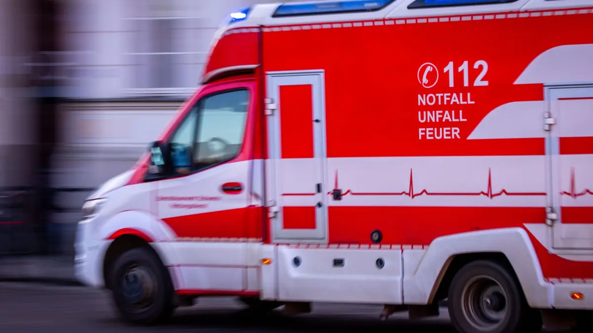 Rettungswagen mit Blaulicht: ARCHIV - 07.03.2025, Mecklenburg-Vorpommern, Schwerin: Ein Rettungswagen fährt mit Blaulicht bei einem Noteinsatz durch die Innenstadt. (Aufnahme mit langer Belichtungszeit) (zu dpa: «Anklage gegen Eltern nach tödlichem Badeunfall zweier Kinder») Foto: Jens Büttner/dpa +++ dpa-Bildfunk +++