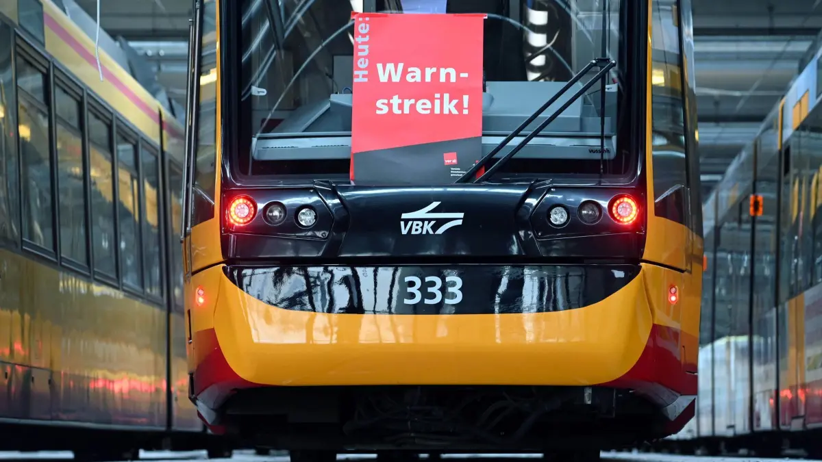 Warnstreiks im Nahverkehr in Karlsruhe: ARCHIV - 25.09.2020, Baden-Württemberg, Karlsruhe: An einer Straßenbahn der Verkehrsbetriebe Karlsruhe hängt ein Plakat mit der Aufschrift Warnstreik. Die Gewerkschaft Verdi will mit den Warnstreiks ihren Forderungen Nachdruck verleihen. (zu dpa: «Verdi-Warnstreik am Montag - Was Pendler wissen müssen») Foto: Uli Deck/dpa +++ dpa-Bildfunk +++