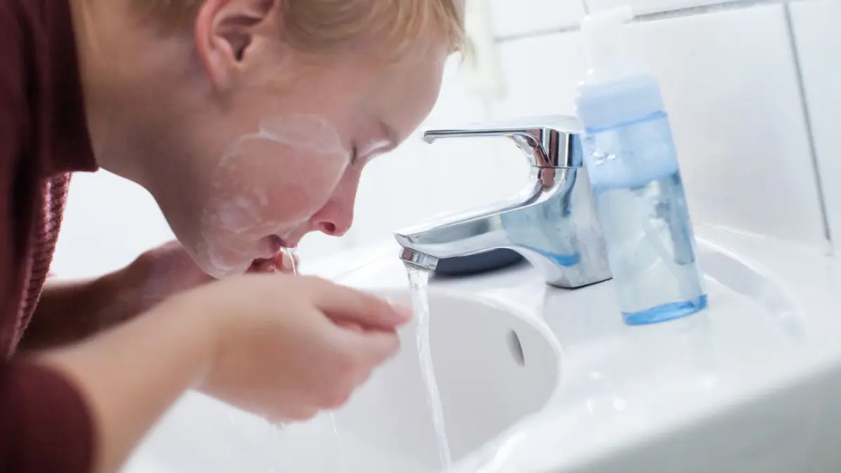 Frau wäscht sich das Gesicht: ILLUSTRATION - Die Haut zweimal am Tag mit sanften Produkten reinigen und pflegen: Wer das tut, tut viel, um Pickeln vorzubeugen - auch wenn es keine Garantie für reine Haut gibt. (zu dpa: «So können wir Pickeln vorbeugen») Foto: Christin Klose/dpa-mag - Honorarfrei nur für Bezieher des Dienstes dpa-Magazin +++ dpa-Magazin +++
