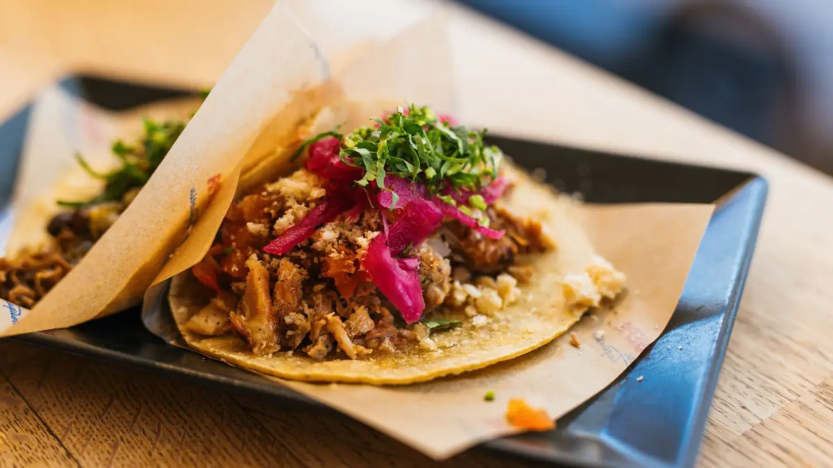 Verpackungssteuer in Freiburg: PRODUKTION - 30.01.2026, Baden-Württemberg, Freiburg: Tacos liegen auf Papieren und einem Teller im Restaurant Yepa Yepa. Die Stadt Freiburg hat zum 1. Januar eine Verpackungssteuer eingeführt, Gastronomen beklagen nun hohe Mehrkosten und ein Übermaß an Bürokratie. (zu dpa: «Aufreger Verpackungssteuer: «Schon eine Frechheit»») Foto: Philipp von Ditfurth/dpa +++ dpa-Bildfunk +++
