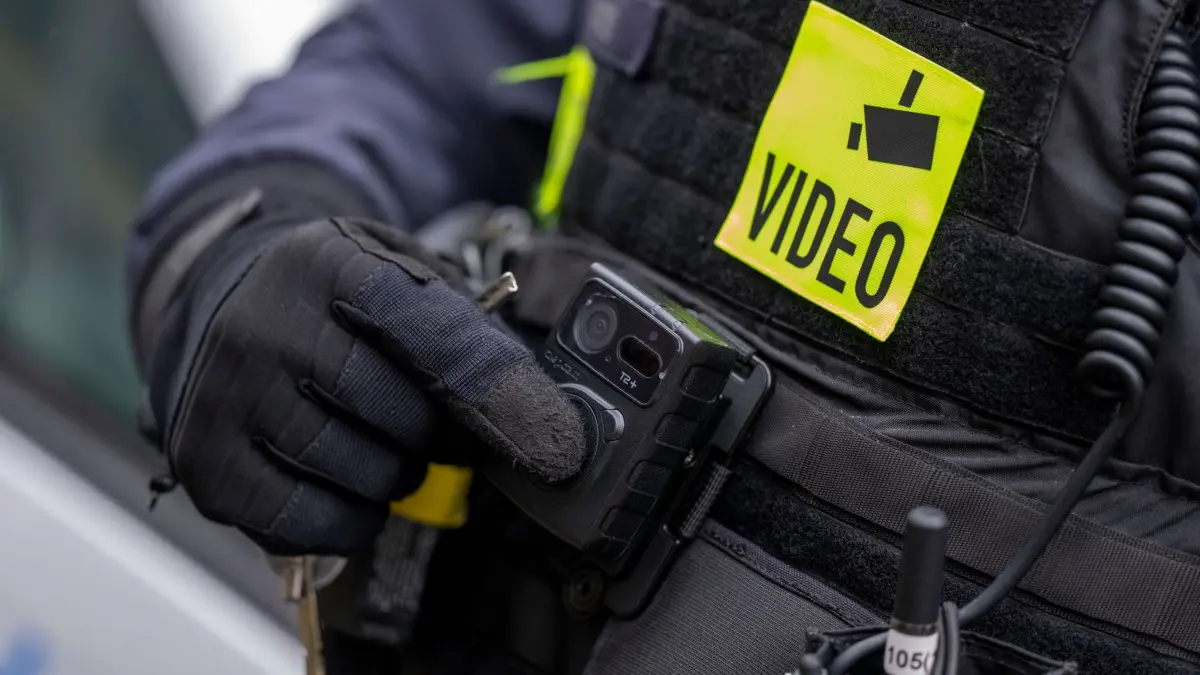 Bodycam: ARCHIV - 05.12.2022, Berlin: Ein Polizist schaltet die Bodycam auf seiner Uniform ein, aufgenommen bei einem Pressetermin zur Ausweitung des Einsatzes von Bodycams bei Berliner Polizei und Feuerwehr. (zu dpa: «Getöteter Zugbegleiter - Ermittler werten Videos aus Zug aus») Foto: Monika Skolimowska/dpa +++ dpa-Bildfunk +++