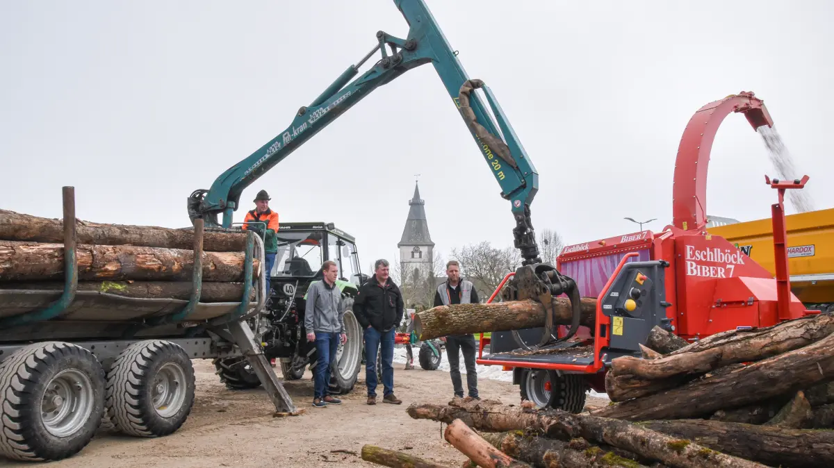 Ein Holzhäcksler verarbeitet bei den Markttagen einen Baumstamm zu Hackschnitzeln.