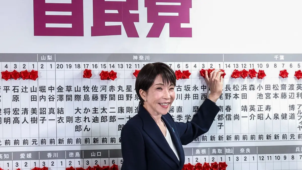 Japan's Prime Minister and President of the Liberal Democratic Party (LDP) Sanae Takaichi places a red paper rose on the name of an elected candidate at the LDP headquarters during the House of Representatives election in Tokyo on February 8, 2026. (Photo by Kim Kyung-Hoon / POOL / AFP)