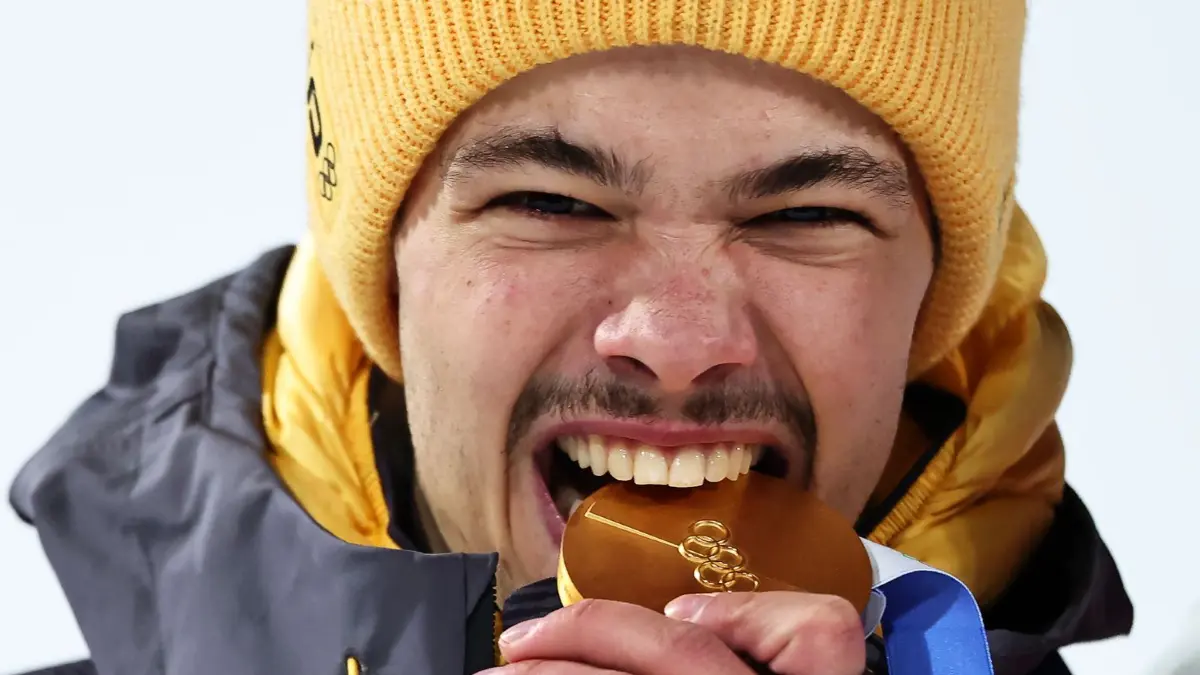 Olympische Winterspiele 2026: 09.02.2026, Italien, Predazzo: Olympia, Olympische Winterspiele Mailand Cortina 2026, Ski nordisch/Skispringen, Normalschanze, Männer, Durchgang 2, Olympiasieger Philipp Raimund (Deutschland) jubelt bei der Siegerehrung mit seiner Goldmedaille über den ersten Platz. Foto: Daniel Karmann/dpa +++ dpa-Bildfunk +++