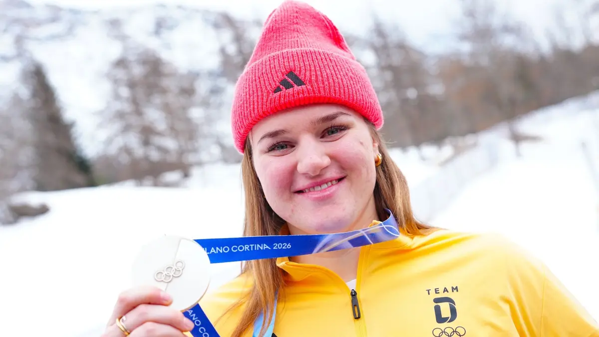 Olympische Winterspiele 2026: 09.02.2026, Italien, Cortina Džampezzo: Olympia, Olympische Winterspiele Mailand Cortina 2026, DOSB, Deutsches Haus, Emma Aicher (Ski alpin) zeigt ihre Silbermedaille (Abfahrt) nach einer Pressekonferenz des deutschen Teams. (zu dpa: «Team-Kombi: Deutsches Duo braucht Überraschung für Medaille») Foto: Michael Kappeler/dpa +++ dpa-Bildfunk +++
