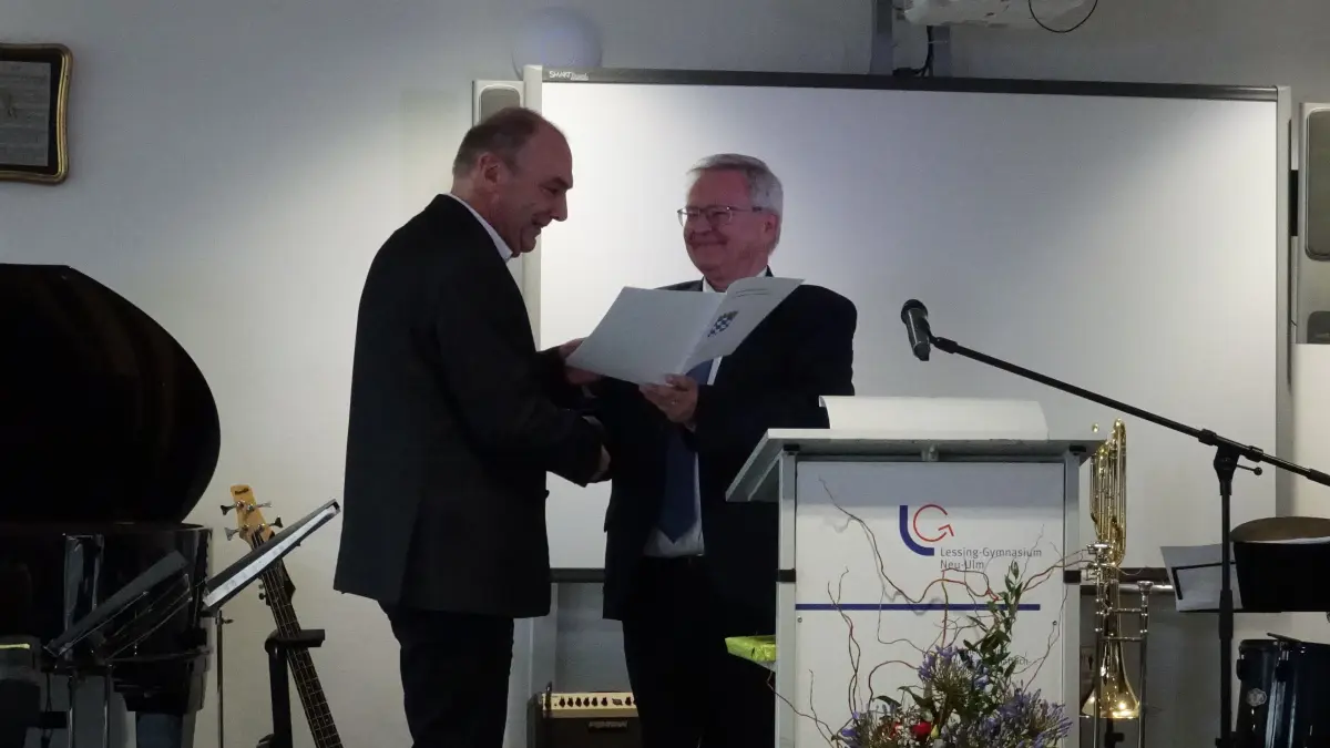 Der entscheidende Moment: Martin Bader, der langjährige Rektor des Lessing-Gymnasiums, bekommt vom Ministerialbeauftragten Christoph Henzler die Entlassungsurkunde überreicht.