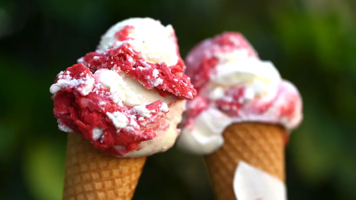 Eis: PRODUKTION - 12.06.2025, Berlin: Zwei Menschen halten jeweils eine Kugel Eis in der Waffel nebeneinander. (zu dpa: «Große Lücken im Finanzwissen? - Crashkurse für Auszubildende») Foto: Michael Brandt/dpa +++ dpa-Bildfunk +++