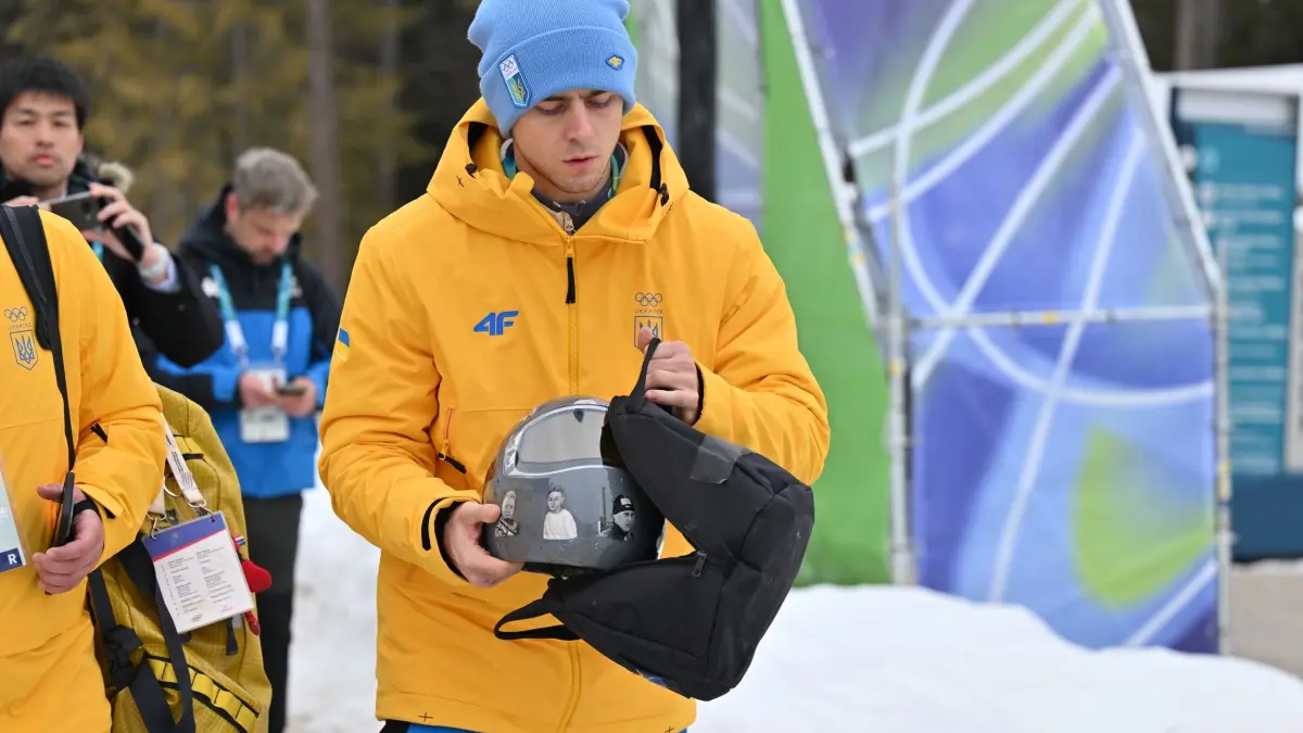 Olympische Winterspiele 2026: 12.02.2026, Italien, Cortina d'Ampezzo: Olympia, Olympische Winterspiele Mailand Cortina 2026, Skeleton, Männer, Wladislaw Heraskewytsch (Ukraine) packt den Helm in seine Tasche. Im Streit um seinen Helm mit Bildern von im Krieg getöteten Sportkollegen ist der Ukrainer Wladislaw Heraskewytsch vom olympischen Skeleton-Wettbewerb ausgeschlossen worden. Foto: Robert Michael/dpa +++ dpa-Bildfunk +++