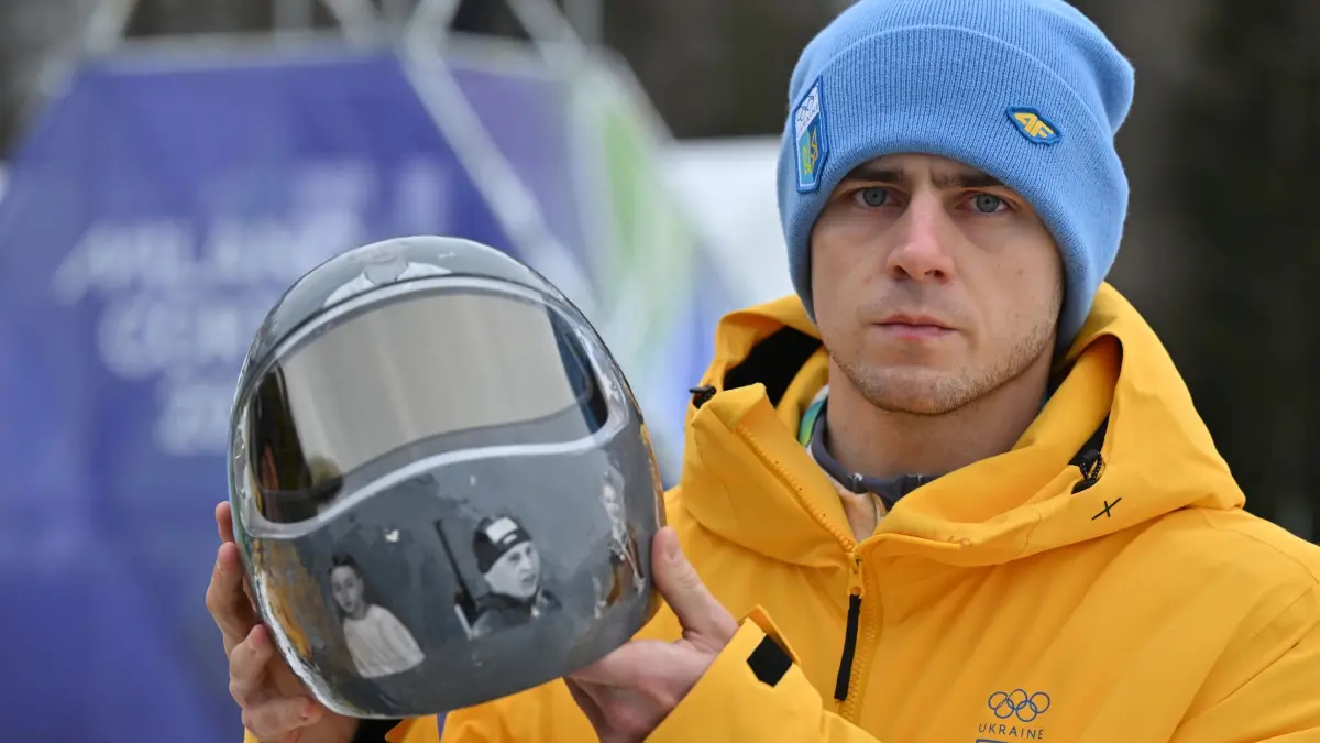 Olympische Winterspiele 2026: 12.02.2026, Italien, Cortina d'Ampezzo: Olympia, Olympische Winterspiele Mailand Cortina 2026, Skeleton, Männer, Wladislaw Heraskewytsch (Ukraine) zeigt seinen Helm. Im Streit um seinen Helm mit Bildern von im Krieg getöteten Sportkollegen ist der Ukrainer Wladislaw Heraskewytsch vom olympischen Skeleton-Wettbewerb ausgeschlossen worden. Foto: Robert Michael/dpa +++ dpa-Bildfunk +++