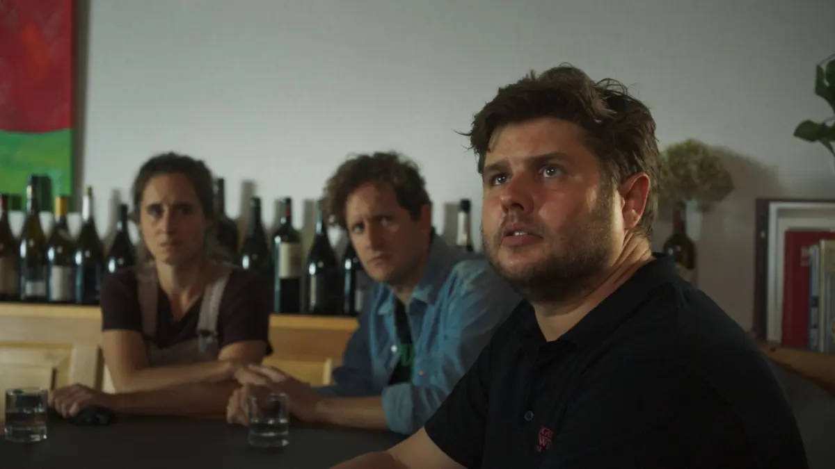 Tessa Mockwitz (Amelie Kiefer, l.), ihr Partner Matthias Glasser (Moritz Treuenfels, M.) und ihr Bruder Sebastian Mockwitz (Sebastian Fritz, r.) zeigen sich schockiert darüber, dass ein Toter im Keller ihres Weinguts gefunden wurde.