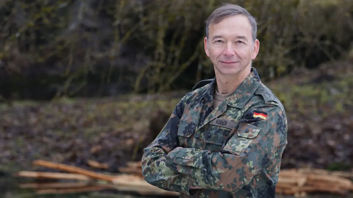 Militärpfarrer Pascal Kober in Uniform, die bei den Seelsorgern Schutzkleidung heißt. Auf den Schulterklappen trägt er anstelle des Dienstgradabzeichens ein Kreuz.