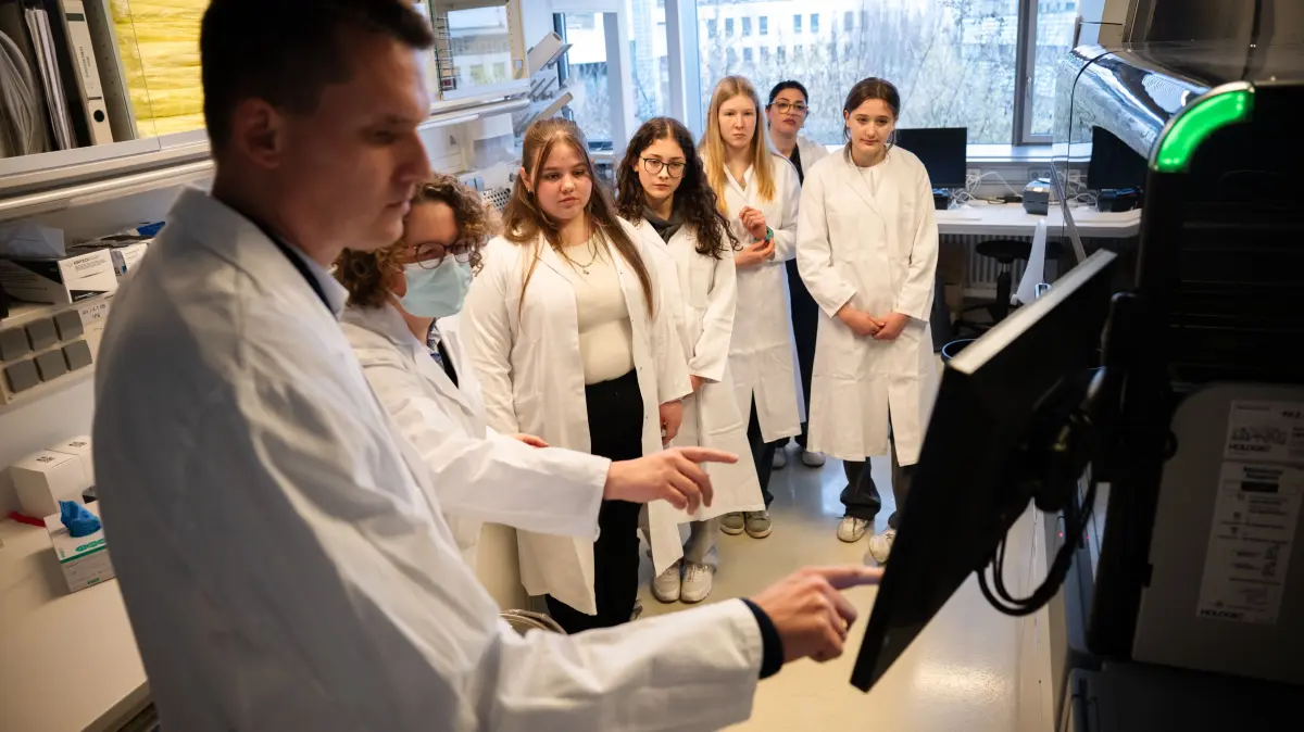 Tina Ganzenmüller (mit Mundschutz) führte vier Schülerinnen und ihre Lehrerin (ganz hinten) aus Schwaikheim durch die Labore. Hier erklärt sie ein Testgerät (rechts), mit dem man unter anderem HPV-Viren testen kann.