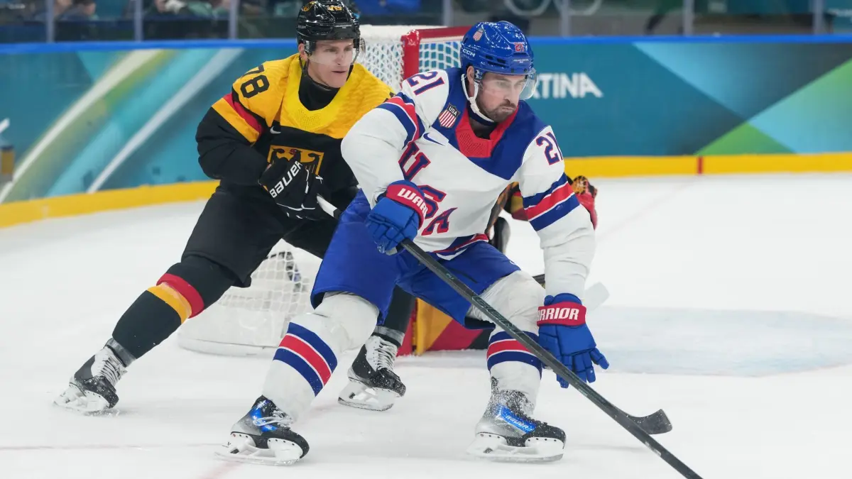 Olympische Winterspiele 2026: 15.02.2026, Italien, Mailand: Olympia, Olympische Winterspiele Mailand Cortina 2026, Eishockey, Männer, USA - Deutschland, Vorrunde, Gruppe C, Spieltag 3, Dylan Larkin (r) aus den USA fordert Nico Sturm aus Deutschland. Foto: Carolyn Kaster/AP/dpa +++ dpa-Bildfunk +++