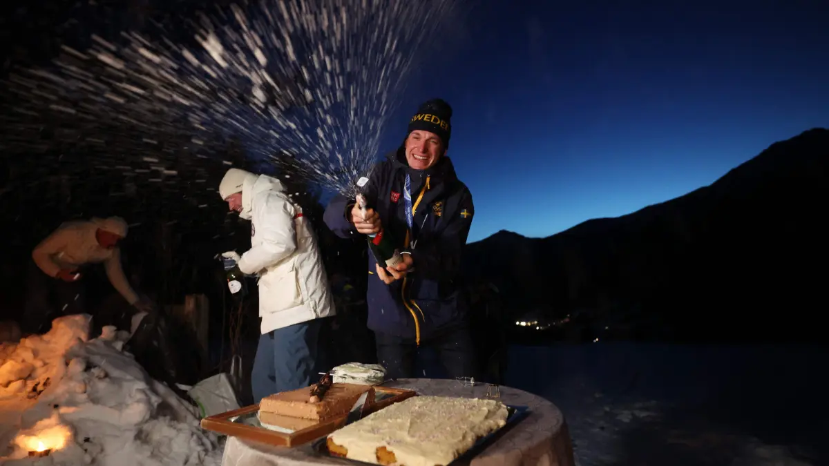 776396064: Gold medallist Sweden's Martin Ponsiluoma (R) celebrates his victory at his hotel after the men's biathlon 12,5km pursuit event during the Milano Cortina 2026 Winter Olympic Games in Anterselva (Val Pusteria) on February 15, 2026. (Photo by FRANCK FIFE / AFP)