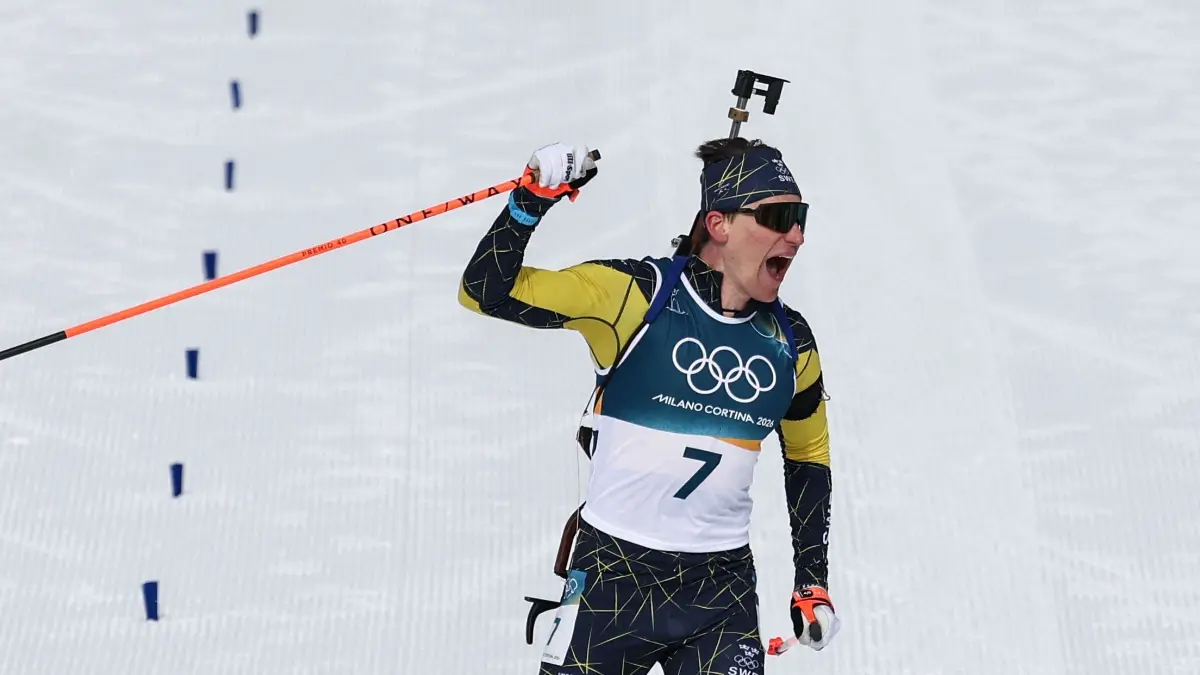 776396064: Sweden's Martin Ponsiluoma celebrates while crossing the finish line during the men's biathlon 12,5km pursuit event during the Milano Cortina 2026 Winter Olympic Games at the Anterselva Biathlon Arena (Sudtirol Arena) in Anterselva (Val Pusteria) on February 15, 2026. (Photo by FRANCK FIFE / AFP)