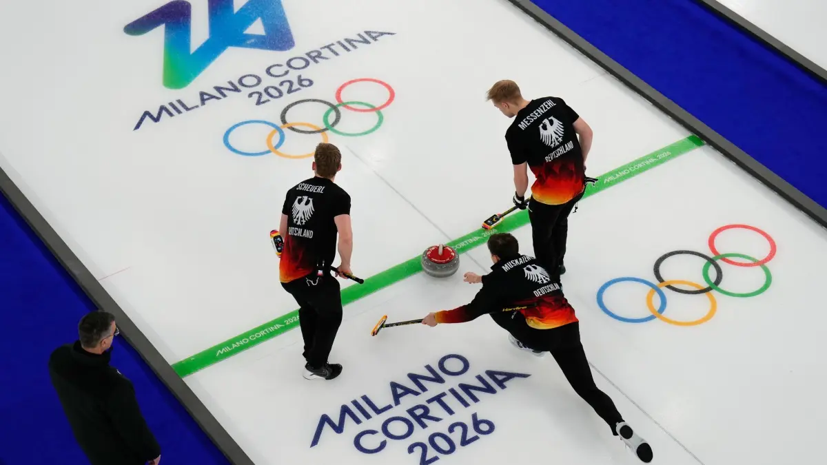 Olympische Winterspiele 2026: 15.02.2026, Italien, Cortina d'Ampezzo: Olympia, Olympische Winterspiele Mailand Cortina 2026, Curling, Männer, Deutschland - Großbritannien, Vorrunde, Spieltag 6, der deutsche Marc Muskatewitz (M) wirft den Stein, während Johannes Scheuerl (l) und Felix Messenzehl sich auf den Wurf vorbereiten, während eines Curling-Rundenwettkampfs der Männer gegen Großbritannien bei den Olympischen Winterspielen 2026 in Cortina d'Ampezzo, Italien, Sonntag, 15. Februar 2026. (AP Photo/David J. Phillip) Foto: David J. Phillip/AP/dpa +++ dpa-Bildfunk +++
