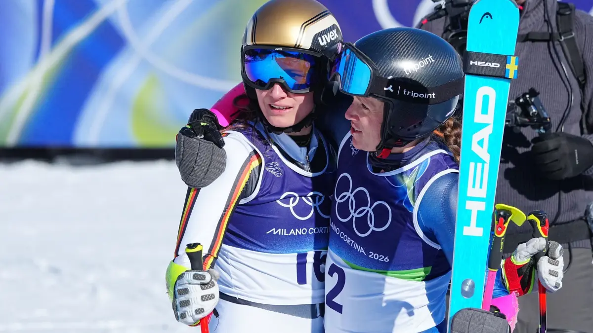 Olympische Winterspiele 2026: 15.02.2026, Italien, Cortina: Olympia, Olympische Winterspiele Mailand Cortina 2026, Ski alpin, Riesenslalom, Frauen, Lauf 2, Tofane Alpine Skiing Centre, Lena Dürr (l, Deutschland) wird im Ziel von Sara Hector (Schweden) getröstet. Foto: Michael Kappeler/dpa +++ dpa-Bildfunk +++