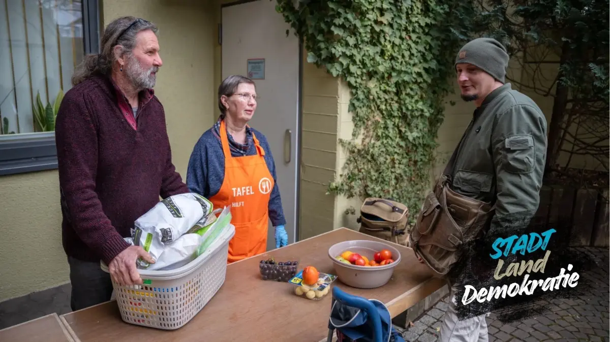 Alex Harscher und eine ehrenamtliche Helferin mit einem Kunden bei der Ausgabe der Mössinger Tafel.