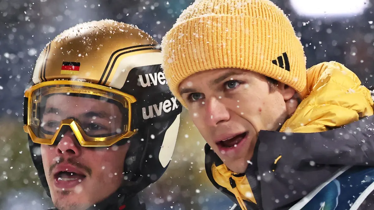 Olympische Winterspiele 2026: 16.02.2026, Italien, Predazzo: Olympia, Olympische Winterspiele Mailand Cortina 2026, Ski nordisch/Skispringen, Super Team, Männer, Finaldurchgang, Philipp Raimund (l, Deutschland) reagiert nach seinem Sprung neben Teamkollege Andreas Wellinger (Deutschland). Foto: Daniel Karmann/dpa +++ dpa-Bildfunk +++