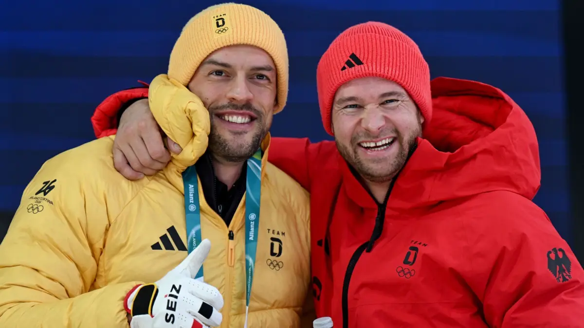 Olympische Winterspiele 2026: 16.02.2026, Italien, Cortina Džampezzo: Olympia, Olympische Winterspiele Mailand Cortina 2026, Bob, Zweierbob, Männer, Durchgang 2, Cortina Sliding Centre, Johannes Lochner (r, Pilot) und Georg Fleischhauer (Deutschland) freuen sich nach Lauf 2. Foto: Robert Michael/dpa +++ dpa-Bildfunk +++