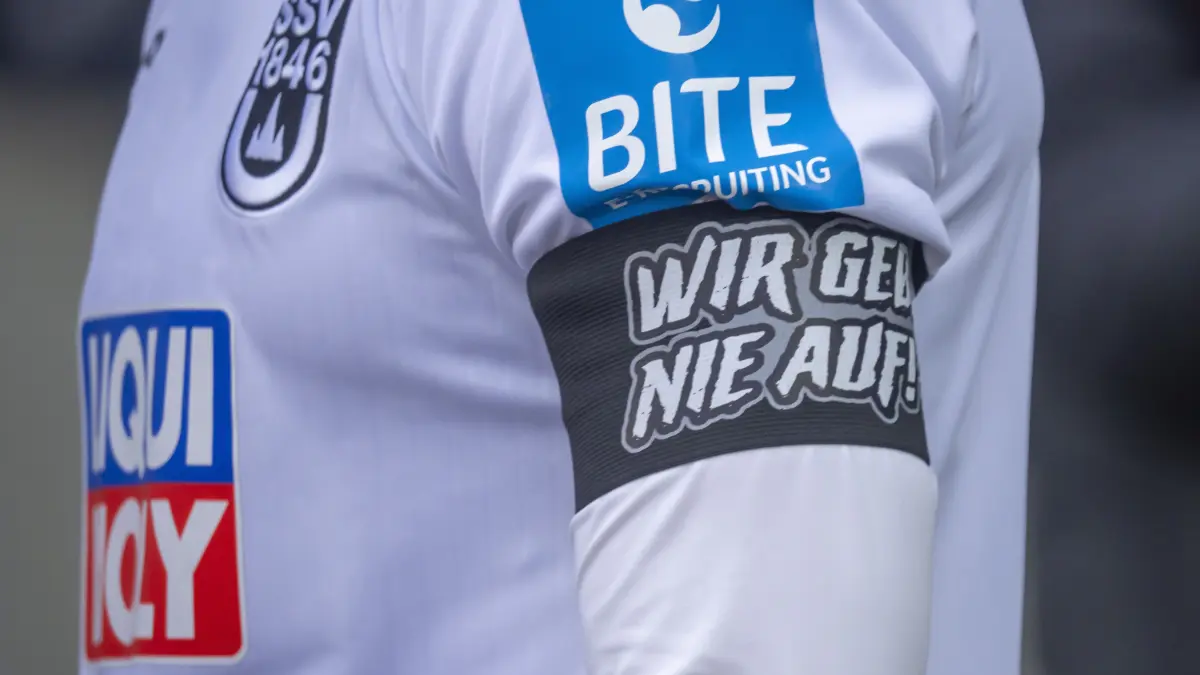 SSV Ulm 1846 Fußball gegen Alemannia Aachen, 3. Liga, 24. Spieltag, Donaustadion, Dennis Dressel, Kapitän, Kapitänsbinde, Wir geben nie auf, Symbol, Heimtrikot 2025/2026, Wappen
