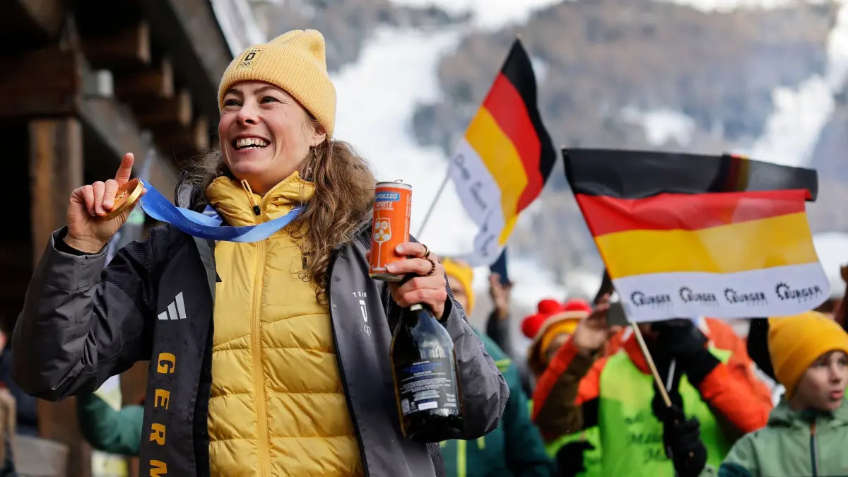 Olympische Winterspiele 2026: 20.02.2026, Italien, Livigno: Olympia, Olympische Winterspiele Mailand Cortina 2026, Ski Freestyle, Ski Cross, Frauen, Finale, Daniela Maier (Deutschland) jubelt mit den Teamkollegen über ihre Goldmedaille. Foto: Oliver Weiken/dpa +++ dpa-Bildfunk +++