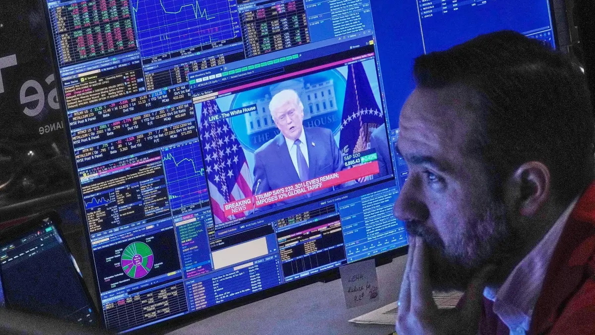 US-Zollpolitik - Wall Street: 20.02.2026, USA, New York: US-räsident Donald Trump erscheint auf dem Bildschirm des Händlers Robert Greason auf dem Parkett der Wertpapierbörse (NYSE). Foto: Richard Drew/AP/dpa +++ dpa-Bildfunk +++