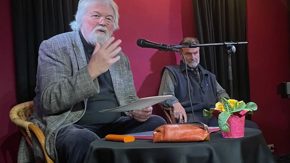 Titus Simon liest im Häberlen aus "Zwei trauen sich was". Hinten: Helmut Knupfer, Saxophonist der "Jazzmen".