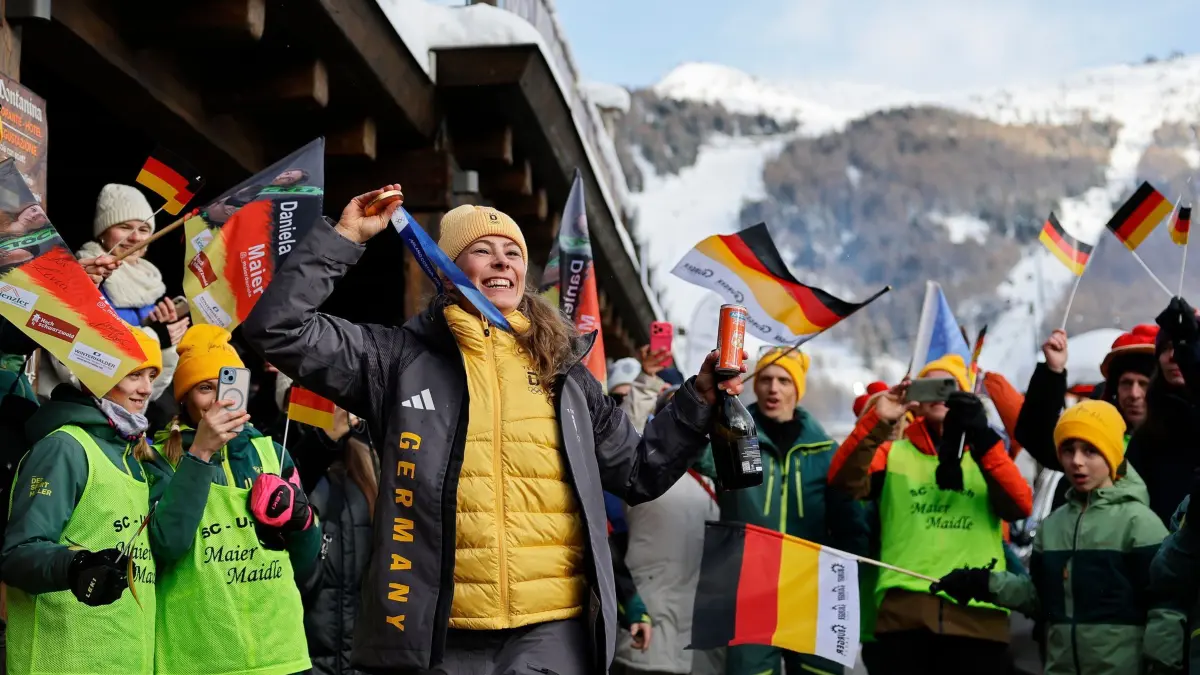 Olympische Winterspiele 2026: 20.02.2026, Italien, Livigno: Olympia, Olympische Winterspiele Mailand Cortina 2026, Ski Freestyle, Ski Cross, Frauen, Finale, Daniela Maier (M, Deutschland) jubelt mit den Teamkollegen über ihre Goldmedaille. Foto: Oliver Weiken/dpa +++ dpa-Bildfunk +++