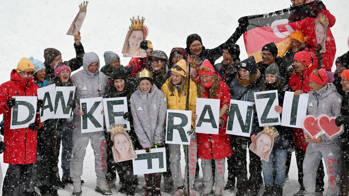 Olympische Winterspiele 2026: 21.02.2026, Italien, Antholz: Olympia, Olympische Winterspiele Mailand Cortina 2026, Biathlon, Frauen, Massenstart 12,5 Kilometer, Anterselva Biathlon Arena, das Team hat sich mit Buchstabenkarten die den Schriftzug "Danke Franzi" bilden um Franziska Preuß aus Deutschland zum Abschied aufgestellt. Foto: Hendrik Schmidt/dpa +++ dpa-Bildfunk +++