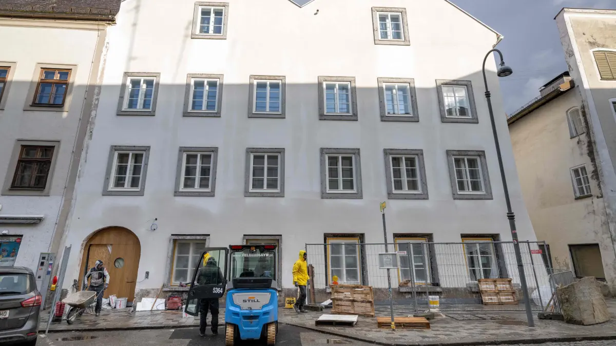Workers are finishing works at the birth house of former German dictator Adolf Hitler that is turned into a police station, pictured on February 17, 2026 in Braunau am Inn, Austria. The controversial redesign of the house in the northern Austrian town of Braunau started in 2023. Following years of legal wrangling, the government took control of the dilapidated building in 2016 and decided to turn the house, where Hitler was born in 1889, into a police station. (Photo by Joe Klamar / AFP)