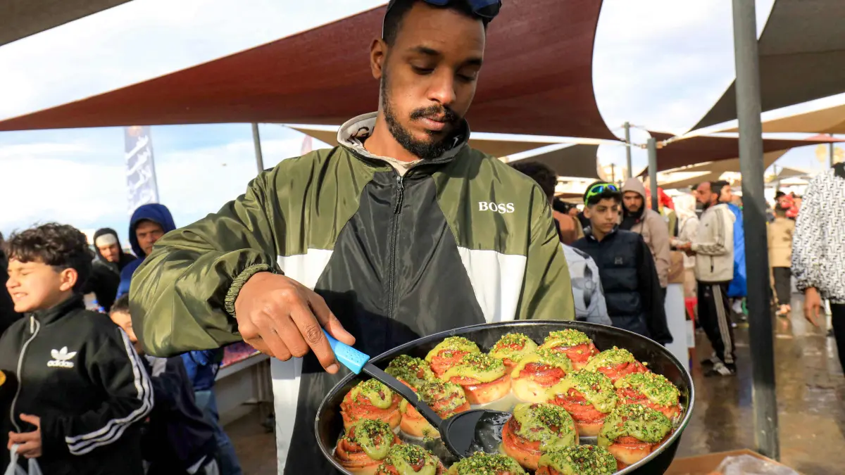 A vendor sells pastry dessert rolls at a market in Libya's eastern city of Benghazi on February 22, 2026, during the Muslim holy fasting month of Ramadan. (Photo by Abdullah DOMA / AFP)