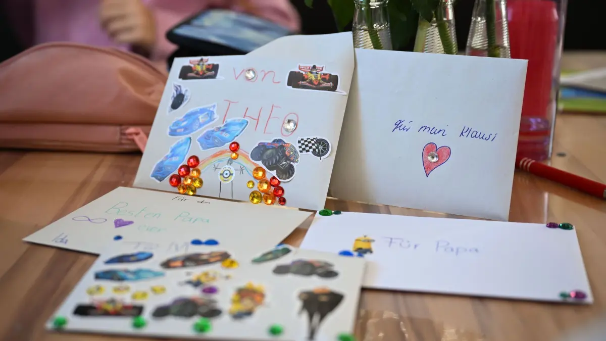 Grabsteine mit Briefschlitz: PRODUKTION - 17.02.2026, Baden-Württemberg, Bad Wildbad: Briefe der Familie Schmid an den den Vater liegen auf dem Esstisch. Der Familienvater starb 2023 an Krebs. Auf seinem Grab steht ein Grabstein mit Briefschlitz, in den die Familie Briefe einwerfen kann. Foto: Katharina Kausche/dpa +++ dpa-Bildfunk +++