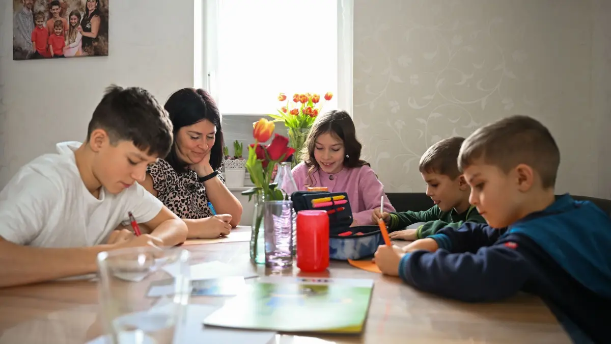 Grabsteine mit Briefschlitz: PRODUKTION - 17.02.2026, Baden-Württemberg, Bad Wildbad: Ben (l-r), Ida, Theo und Tom basteln gemeinsam mit ihrer Mutter Christina Schmid an Briefen für ihren Vater. Der Familienvater starb 2023 an Krebs. Auf seinem Grab steht ein Grabstein mit Briefschlitz, in den die Familie Briefe einwerfen kann. Foto: Katharina Kausche/dpa - ACHTUNG: Nur zur redaktionellen Verwendung im Zusammenhang mit der aktuellen Berichterstattung und nur mit vollständiger Nennung des vorstehenden Credits +++ dpa-Bildfunk +++
