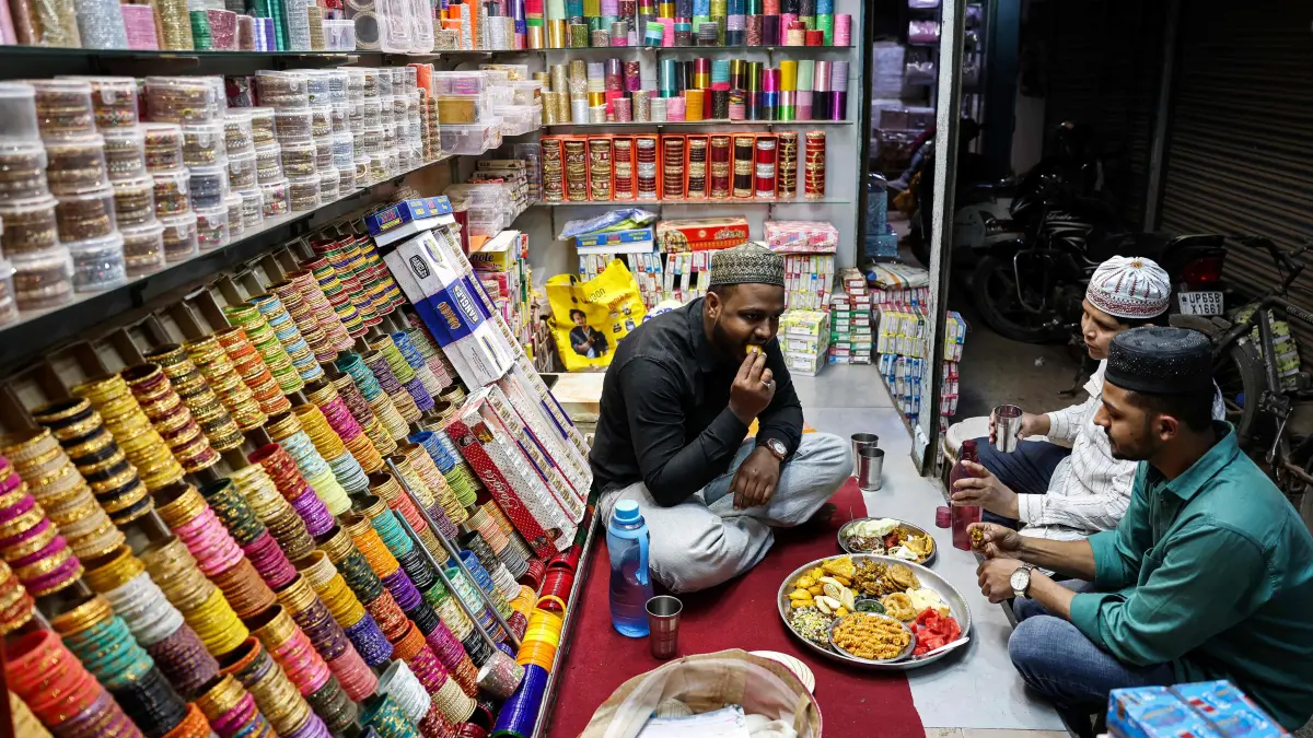 Muslim shopkeepers break their fast during the Islamic holy fasting month of Ramadan in Varanasi on February 24, 2026. (Photo by Niharika KULKARNI / AFP)