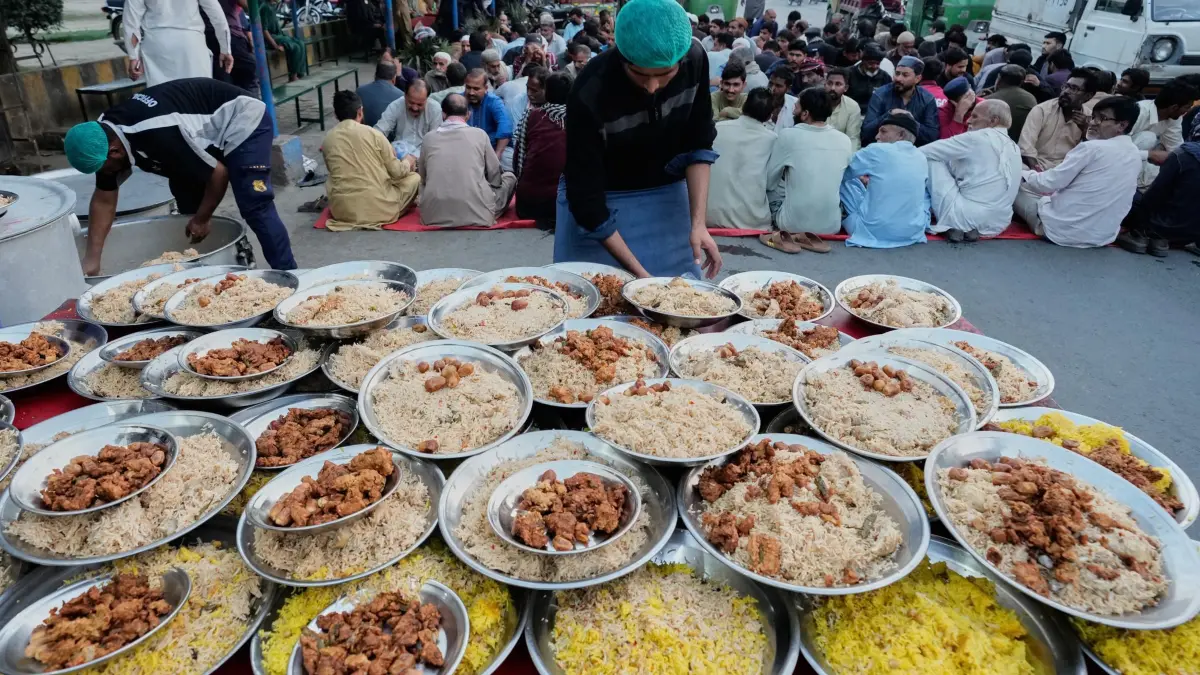 Ramadan in Pakistan: 25.02.2026, Pakistan, Lahore: Ein Freiwilliger bereitet Essenstafeln vor, die während des muslimischen Fastenmonats Ramadan in Lahore, Pakistan, an die Menschen zum Fastenbrechen verteilt werden sollen. Foto: K.M. Chaudary/AP/dpa +++ dpa-Bildfunk +++