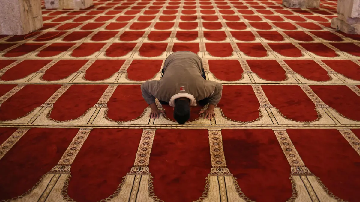A Palestinian man prays inside al-Marawani mosque located at the al-Aqsa mosque compound in Jerusalem ahead of the "iftar" fast-breaking meal during the Muslim holy month of Ramadan on February 25, 2026. (Photo by AHMAD GHARABLI / AFP)