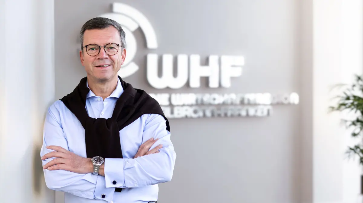 Will ein Zeichen setzen: WHF-Geschäftsführer Bernhard Feßler vor dem neuen Logo der Gesellschaft.