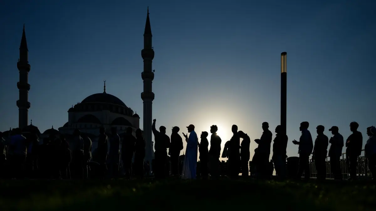 Ramadan in den Vereinigte Arabische Emirate: 27.02.2026, Vereinigte Arabische Emirate, Sharjah: Muslimische Gläubige sind zu sehen, als sie zum Fastenbrechen während des heiligen Monats Ramadan in der Großen Moschee ankommen. Foto: Altaf Qadri/AP/dpa +++ dpa-Bildfunk +++