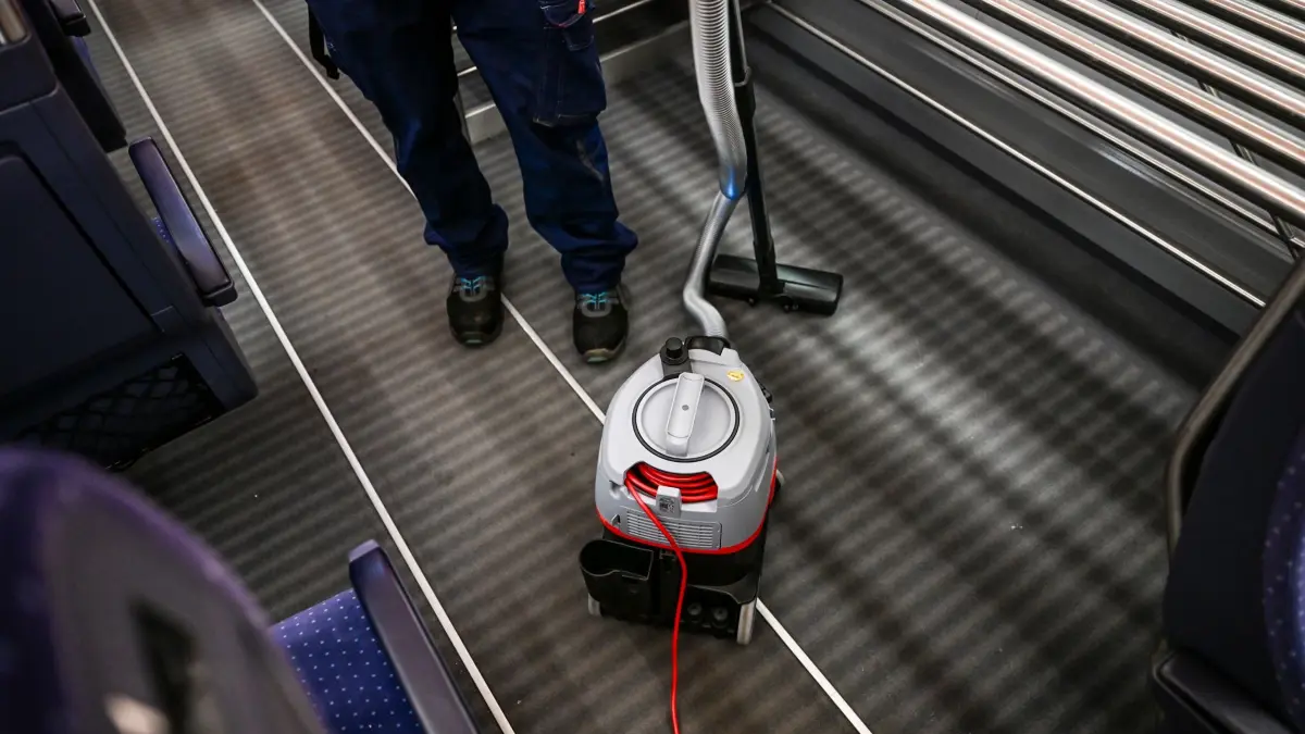 Deutsche Bahn mit Sofortprogramm für mehr Komfort: 27.02.2026, Berlin: Eine Reinigungskraft mit einem Staubsauger in einem Zug im ICE Betriebswerk Berlin-Rummelsburg bei der Vorstellung vom Sofortprogramm für mehr Komfort im Fernverkehr. Dabei sollen mehr Reinigungskräfte in den Zügen arbeiten und schnellere Reparaturen von Toiletten und im Bordbistro durchgeführt werden. (zu dpa: «Deutsche Bahn startet Sofortprogramm für mehr Komfort im Zug») Foto: Jens Kalaene/dpa +++ dpa-Bildfunk +++