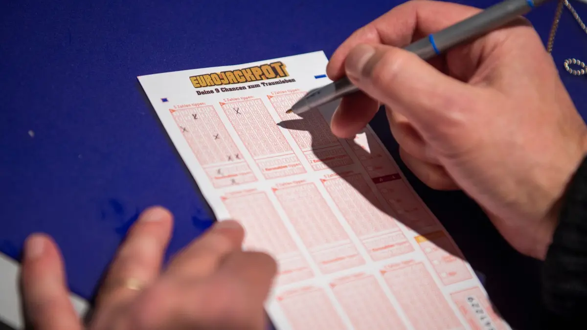 Mann kreuzt auf Lottoschein des Spiels „Eurojackpot“ Zahlen an