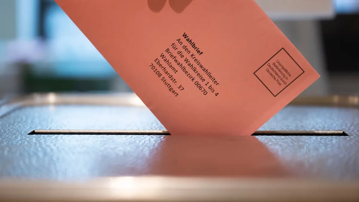 Landtagswahl in Baden-Württemberg - Briefwahl: PRODUKTION - 11.02.2026, Baden-Württemberg, Stuttgart: Ein Wähler steckt im Rathaus ihren Briefwahlumschlag zur baden-württembergischen Landtagswahl 2026 in eine Wahlurne. (zu dpa: «Briefwahl: Fristen, Unterlagen und Tipps zur Landtagswahl») Foto: Marijan Murat/dpa +++ dpa-Bildfunk +++