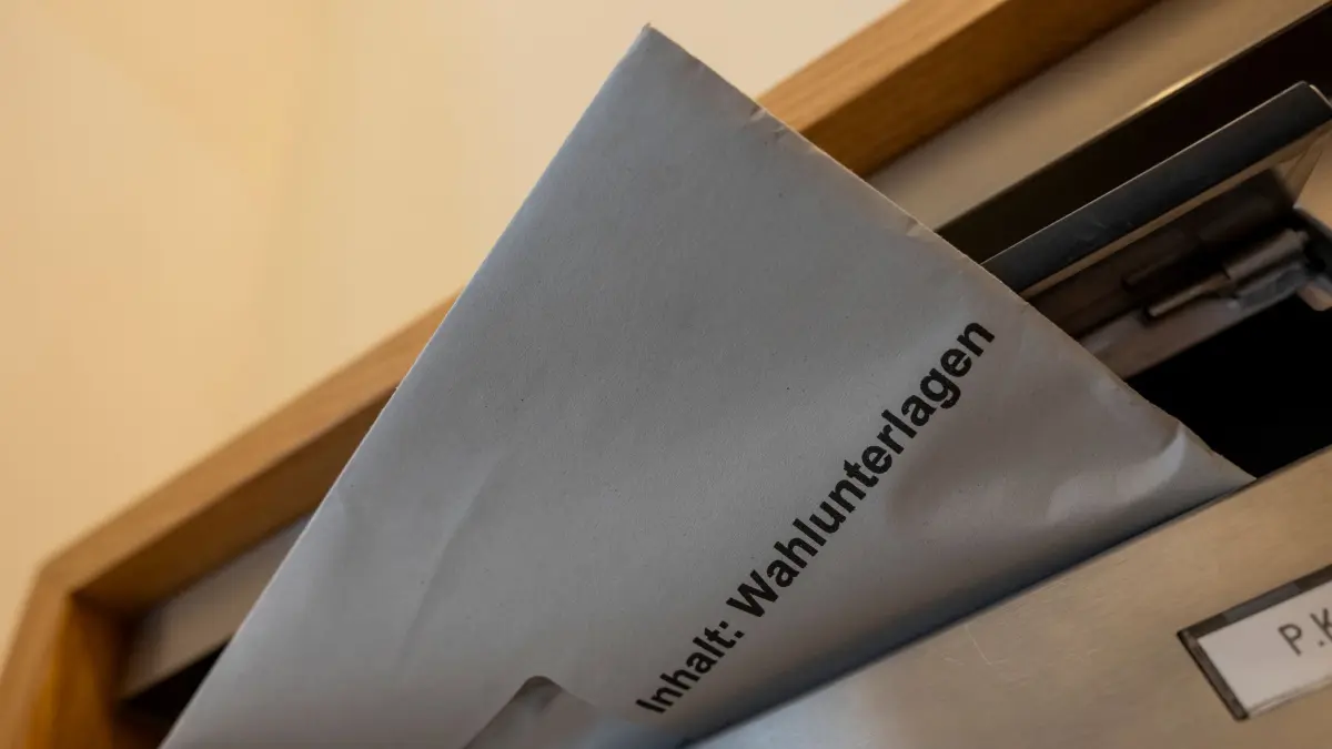Komunalwahlen in Bayern: 02.03.2026, Bayern, München: ILLUSTRATION - Wahlunterlagen für die Briefwahl stecken in einem Briefkasten. Die bayerische Kommunalwahl findet am 8. März 2026 statt. Foto: Peter Kneffel/dpa +++ dpa-Bildfunk +++