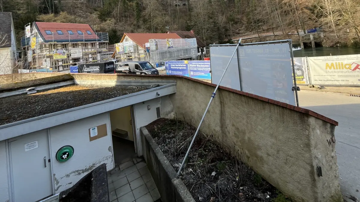 Der öffentlich zugängliche Defibrillator an der Toilettenanlage neben dem Blautopf ist gestohlen worden. Im Foto ist nur noch die leere grüne Wandhalterung zu sehen.