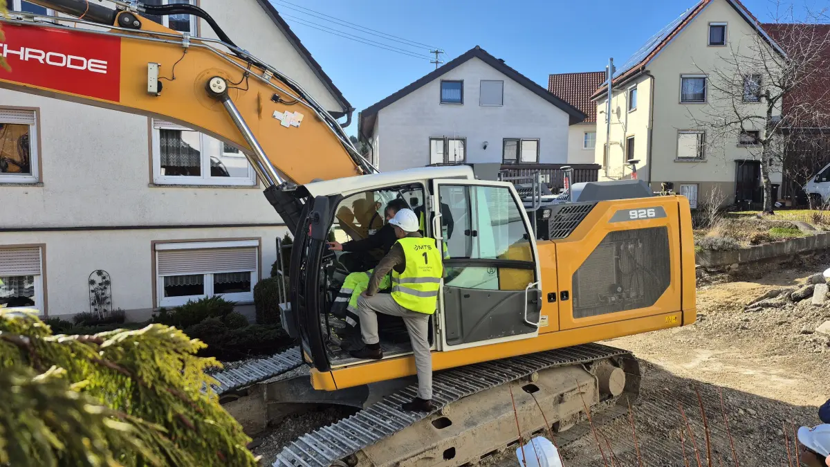 Pilotbaustelle in St. Johann-Bleichstetten. Innenminister Thomas Strobl lässt sich zeigen, was der Baggerfahrer auf dem integrierten Bildschirm alles sehen kann.