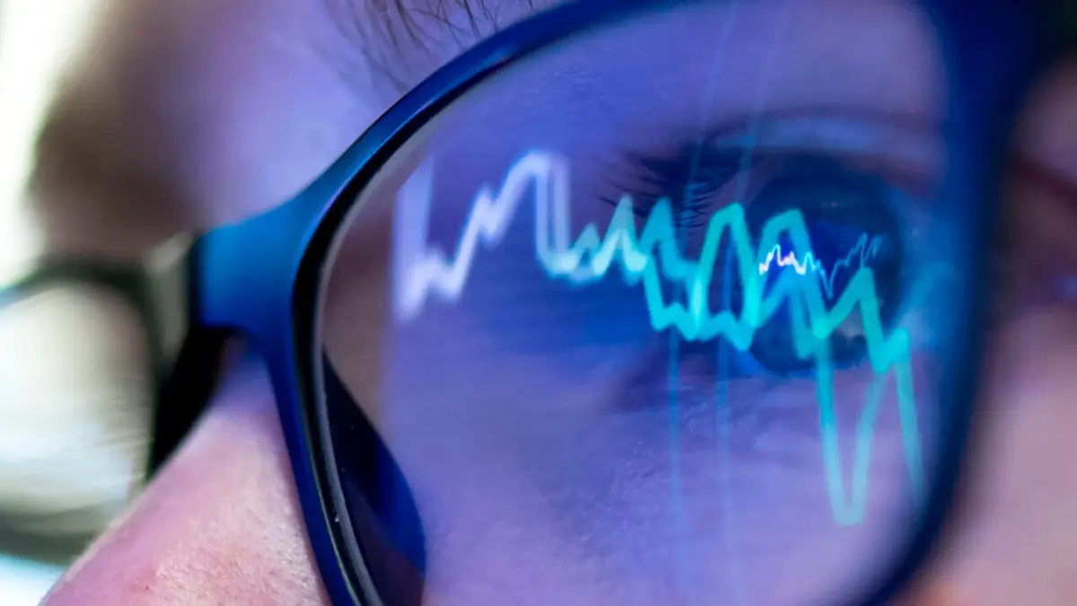 Börsenkurse spiegeln sich in einer Brille wieder